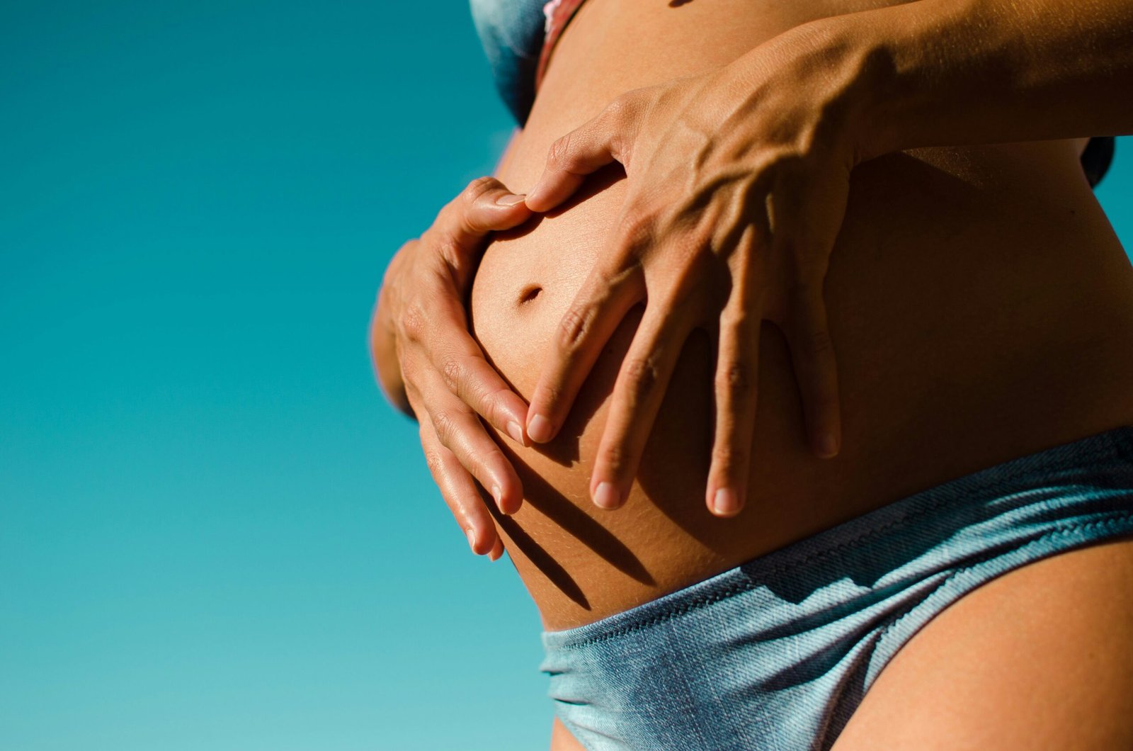 closeup photography of pregnant woman wearing blue panty